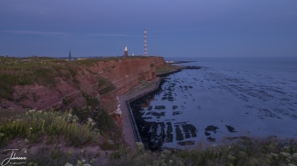 Klifs op Helgoland tijdens blauwe uur met vuurtoren