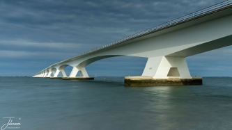 The Zeeland Bridge is an impressive structure over five kilometres long and connects Schouwen-Duiveland (Zierikzee) and Noord-Beveland (Colijnsplaat). The bridge consists of 54 piers with 52 spans of 95 meters each.
On a nice day at the end of September I travelled to this location. In the afternoon, it became very cloudy with sunbeams shining through the clouds, glistening on the bridge.