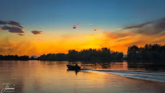 We just arrived in Crisan (Roemenie). A speedboot brought us from Tulcea. Tomorrow, we are going in the Danube delta. However in the evening, we were treated by a beautiful sunset. Something was on fire on the left side at which the sun is shining. Many boats are passing by over the canel giving this very nice picture.