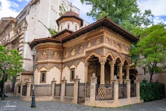 A quiet corner of history preserved. This exquisite church, decorated with intricate frescoes and carved stone columns, is a stunning example of the Brâncovenesc architectural style. Its detailed artistry stands as a vivid contrast to the modern city surrounding it.