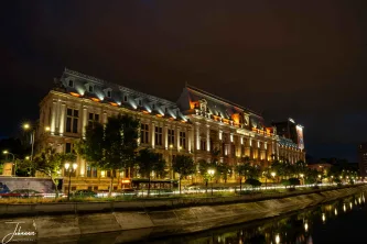 The majestic facade of this historic Bucharest landmark is bathed in golden light, its grandeur perfectly mirrored in the still water of the Dâmbovița River. An exquisite portrait of a capital city at rest.